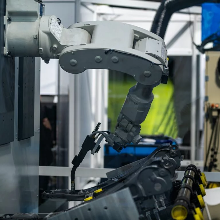 Robotic arm welding system in a manufacturing production plant