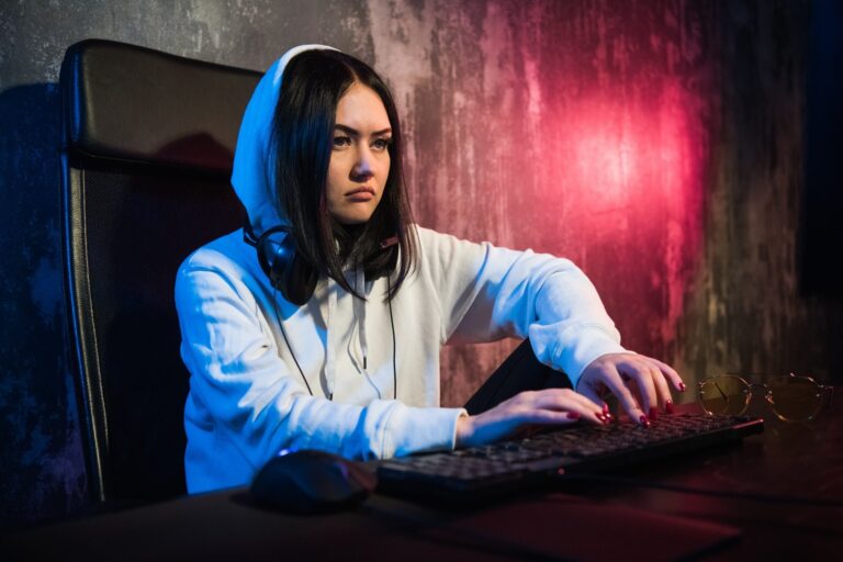 Woman hacker wearing an hood in front of computer screen