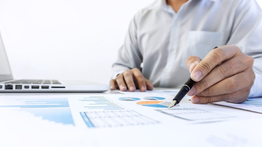 Businessman accountant working audit and calculating expense financial data on graph documents